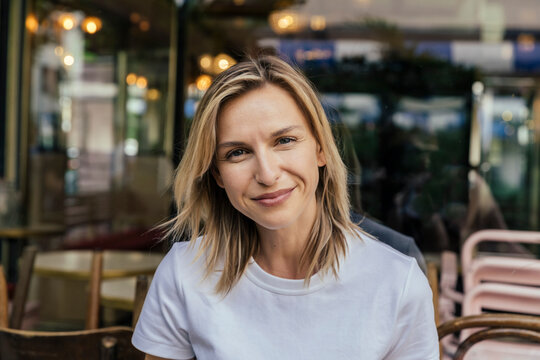 Portrait of smiling woman in front of a coffee shop