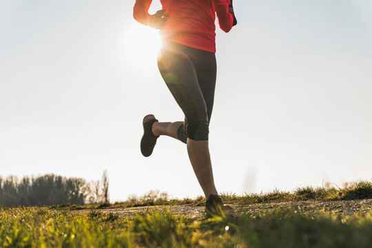 Low section of woman running on rural path