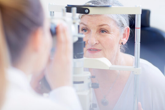 Eye doctor examining senior woman's vision
