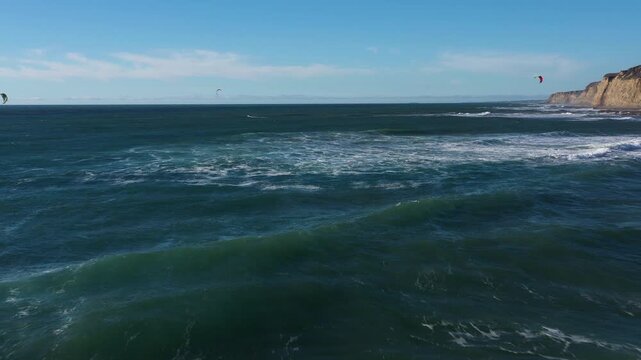Midday drone backward tracking surf to beach