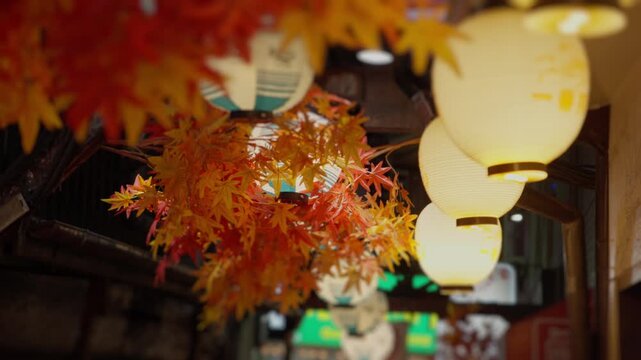 Japanese paper lanterns and maple leaves illuminating a street