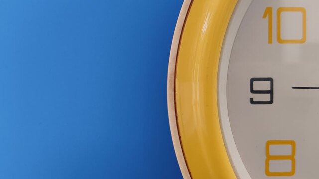 Ticking movement of analog clock second pointer dial or needle half view isolated on blue wall background with copy space. Time wasting, passing, slip, and countdown concept. Closeup front view.
