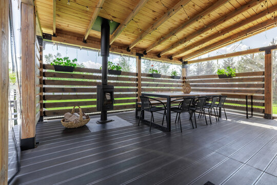 Wide View of Covered Wooden Terrace with Stove and Dining Area