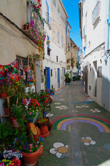 Fototapeta premium Charming traditional street in Chelva, Valencia, Spain, featuring colorful facades, flower pots, and authentic Mediterranean architecture. A picturesque destination reflecting local heritage