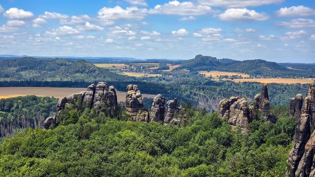 ​Scenic view of the Schrammsteine rock formations and Falkenstein in Saxon Switzerland National Park under a blue sky 