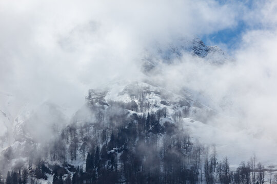 Snow-capped peak pierces through thick cloud layers