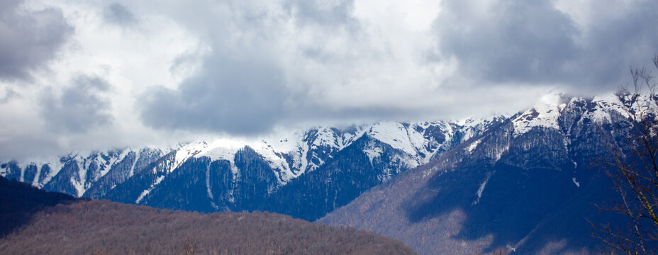 Snow-capped peaks rise against a cloudy sky