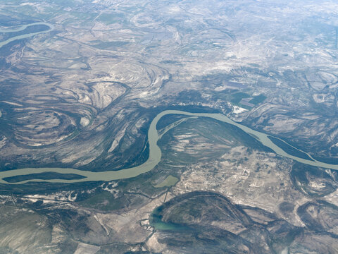 Aerial view of a winding river through a rugged, arid landscape