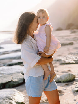 Mother with her baby girl on sea beach with sunshine. Happy moments