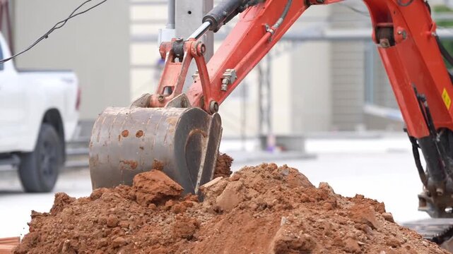 Excavator bucket soil construction digging earthmoving machinery work equipment, heavy equipment lifting dirt, hydraulic arm closeup dumping clay at roadwork site, outdoor excavation scene