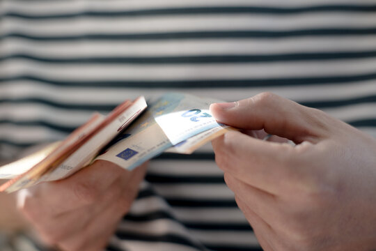 A euro banknote in a man's hand.
