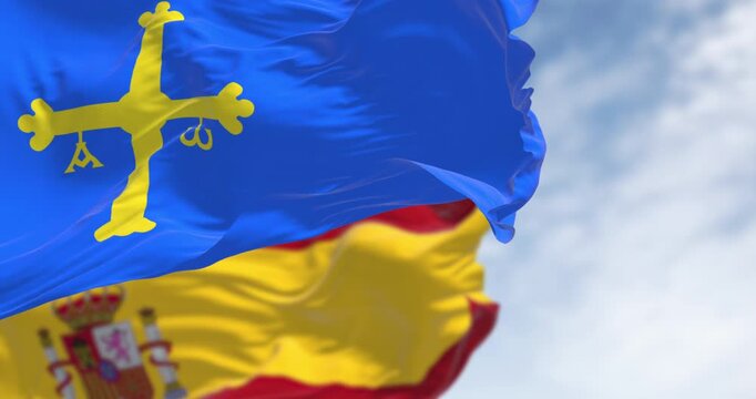 The Asturias flag waving with Spanish flag on a clear day