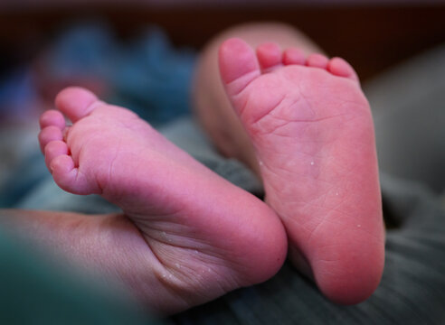 Newborn baby&rsquo;s feet with smooth, delicate skin. Light-colored flaking and dry skin peeling across the soles and heels of a healthy newborn baby's feet.