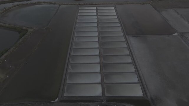 erial drone footage of Long Dien Salt Fields in Ho Chi Minh City, Vietnam, featuring traditional sea salt production, geometric salt ponds, coastal landscape and sustainable local industry.
