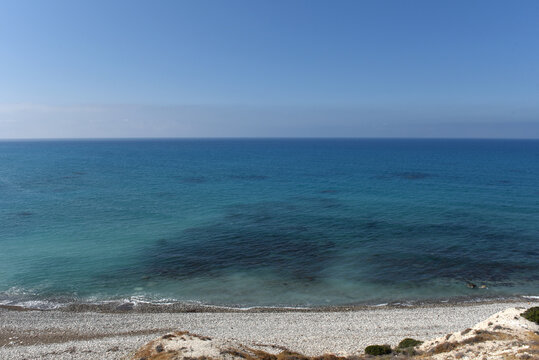 Pebble beach shoreline and vast blue Mediterranean horizon from a high vantage point, Cyprus