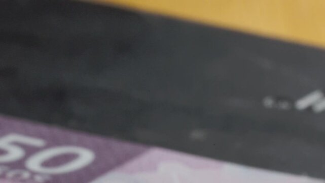 Macro closeup of Mexico fifty peso banknote showing intricate security features and fine details. Shallow focus highlights printed patterns, metallic elements and currency texture