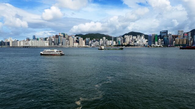 Victoria Harbour skyline and cityscape with ferries in Hong Kong.