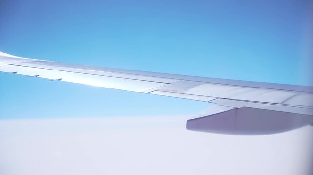 Aircraft cruising high with wingtip and flap track fairings clearly visible against minimal sky background. Simplified composition focusing on construction geometry and surface texture. Airplane