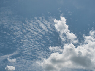 Clear blue sky with thin white clouds forming patterns resembling fish scales or ripples—specifically cirrocumulus clouds often referred to as a buttermilk sky. © saksuvan