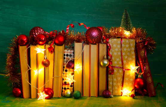 giving books for christmas,christmas  gift,present,reading,literature,education, christmas,holiday concept with heap of books, christmas lights and decoration
