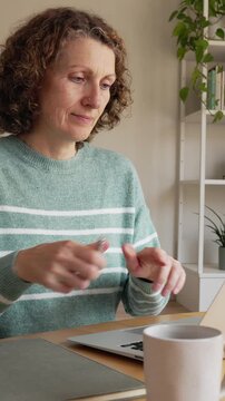 Mature businesswoman typing on laptop computer at home office