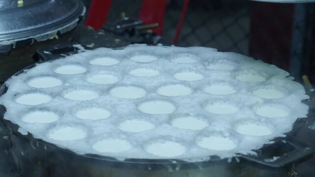 Khanom krok chao wang is a traditional thai dessert made from coconut milk and rice flour, cooked in an iron pan. Common toppings include thinly sliced ​​scallions, taro, corn, or pumpkin.
