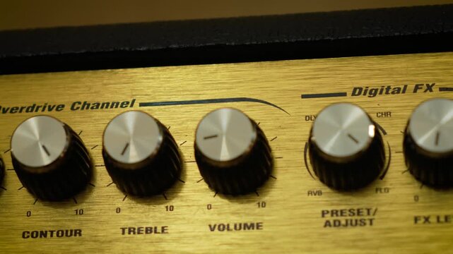 Audio control knobs with volume and equalizer settings in closeup. Metallic rotary dials arranged across professional sound equipment interface. Sound engineering, audio adjustment, and analog