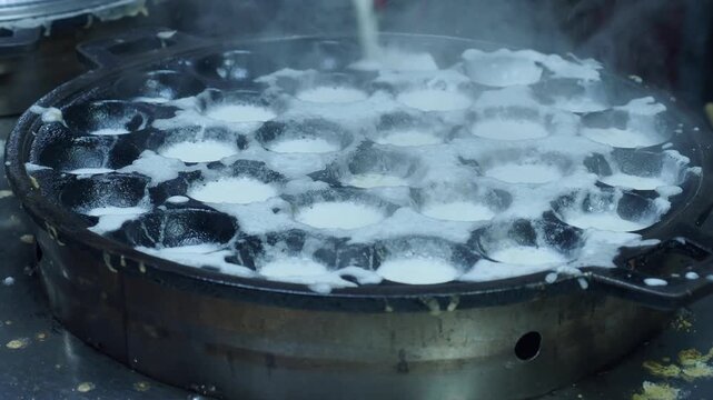 Khanom krok chao wang is a traditional thai dessert made from coconut milk and rice flour, cooked in an iron pan. Common toppings include thinly sliced ​​scallions, taro, corn, or pumpkin.