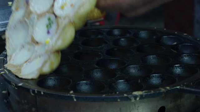 Khanom krok chao wang is a traditional thai dessert made from coconut milk and rice flour, cooked in an iron pan. Common toppings include thinly sliced ​​scallions, taro, corn, or pumpkin.