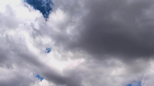 Dark storm clouds gather before heavy rain in time lapse, dramatic weather, atmospheric tension, powerful cloudscape, severe nature background.