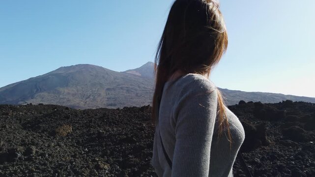 female traveler admiring the iconic Mount Teide volcano. Scenic shot capturing the essence of adventure and freedom in nature