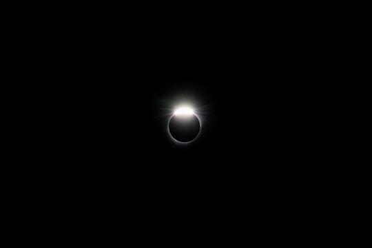solar eclipse with diamond ring near totality and corona