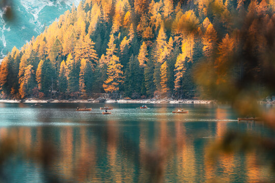 Wooden Rowboats on Turquoise Alpine Lake Surrounded by Autumn Forest in Dolomites Italy