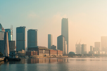 Obraz premium Shanghai City Skyline Waterfront at Golden Hour with Modern Skyscrapers and Hazy Atmosphere in the Morning
