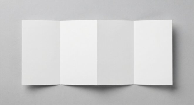Top-down view of a blank white four-panel accordion fold brochure laid flat on light grey textured background with soft shadows.