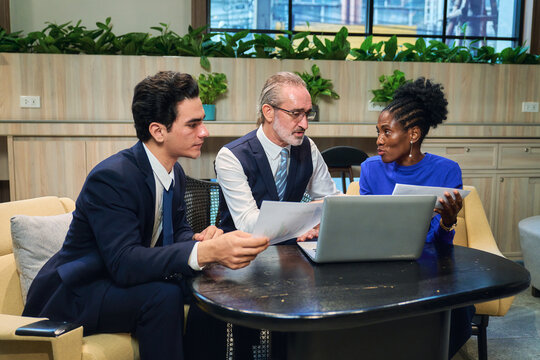 Diverse Business Team Analyzing Data and Strategic Planning in Modern Coworking Space