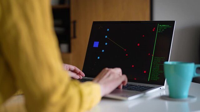 Woman playing retro arcade video game on laptop.