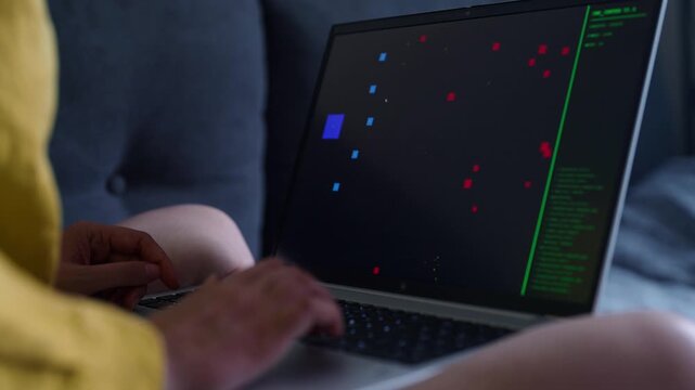 Woman playing retro arcade video game on laptop.