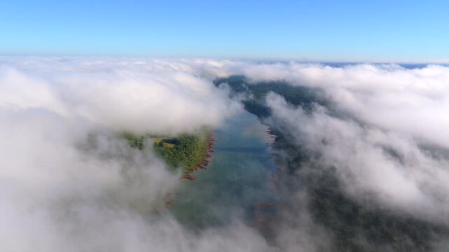 Aerial view of the Parana River cutting through dense morning clouds along the natural border between Argentina and Paraguay.