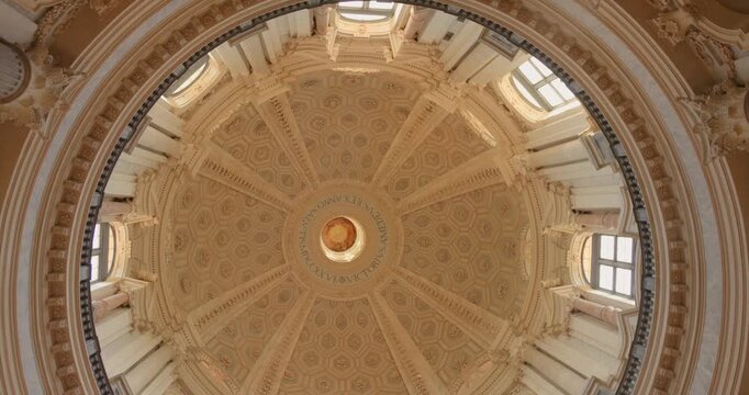 Ornate dome ceiling of Superga Basilica in Turin, Italy framed by bright windows in a static upward view.