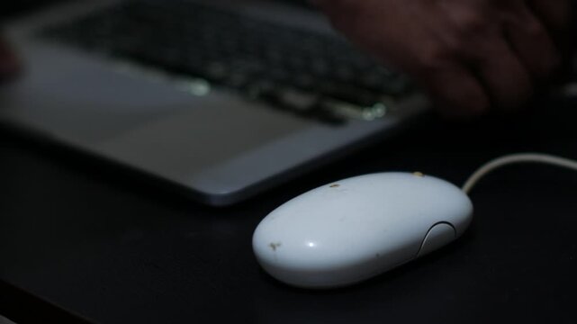 Wired Computer Mouse Beside Laptop in Home Office Workspace