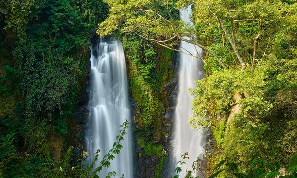 Two beautiful waterfalls Curug Cinulang West Java Indonesia among rocks and the green scenery of trees 