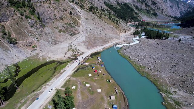 Campsites line the river beside Mahodand Lake and mountain road in Ushu Valley, Khyber Pakhtunkhwa, Pakistan