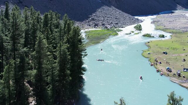 Small boats glide across Mahodand Lake beside cedar forest in Ushu Valley, Khyber Pakhtunkhwa, Pakistan