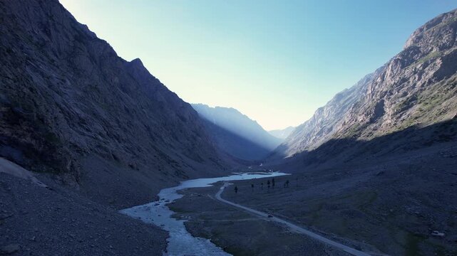 River winds through a steep mountain valley at sunset in Ushu Valley, Hindu Kush, Khyber Pakhtunkhwa, Pakistan