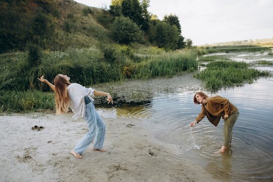 Young women enjoying nature by river bank
