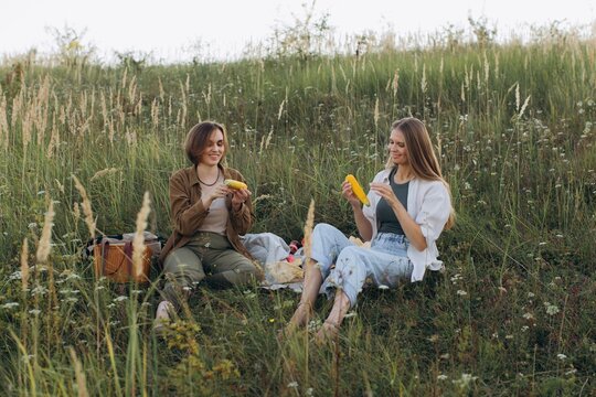 Friends enjoying summer picnic eating corn on cob