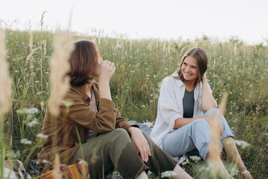 Friends enjoying conversation in summer meadow