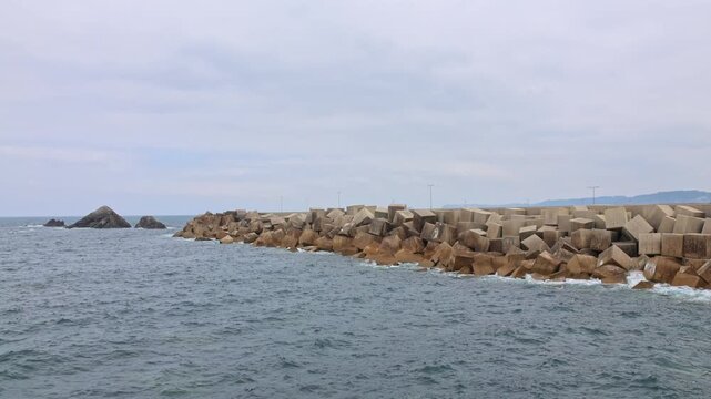 Seascape with massive concrete blocks breakwater and Atlantic ocean on Asturias coast