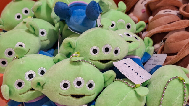 Group of cute green three eyed alien plush toy keychains featuring Disney Pixar character merchandise displayed in retail shop